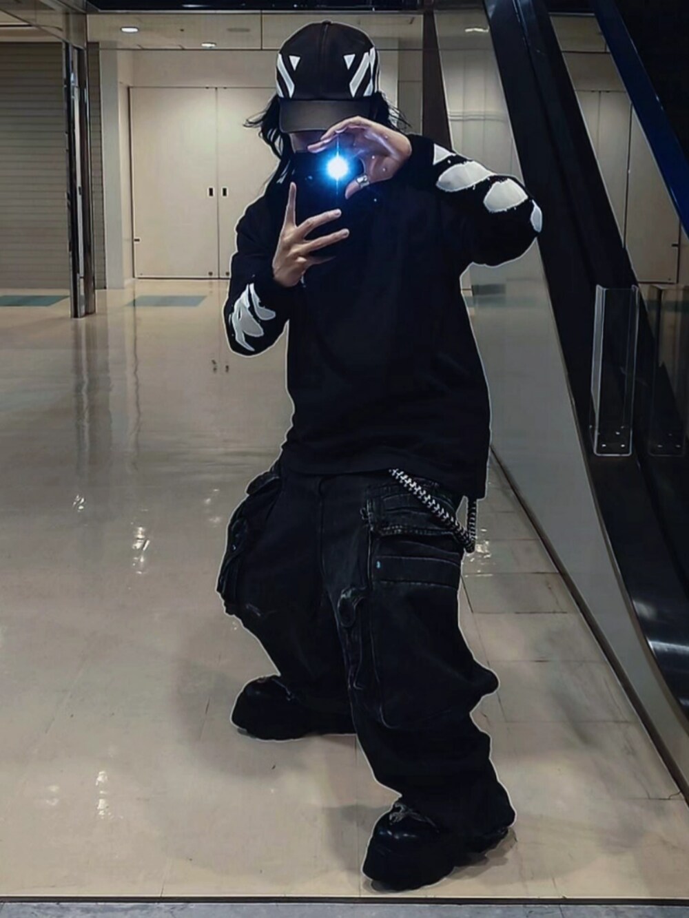 ブルー系のパンツ、ブラック系のブーツ、ブラック系のTシャツ/カットソーを着用したメンズの春コーディネートの2枚目の写真