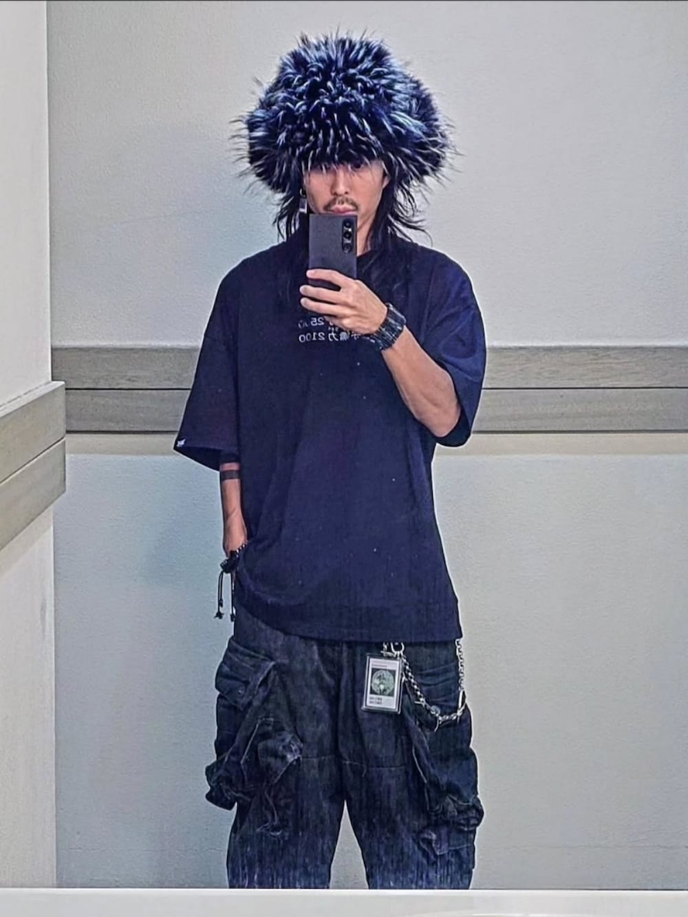 ブラック系のTシャツ/カットソー、グリーン系のカーゴパンツ、ブラック系のキャップを着用したメンズの秋コーディネートの2枚目の写真