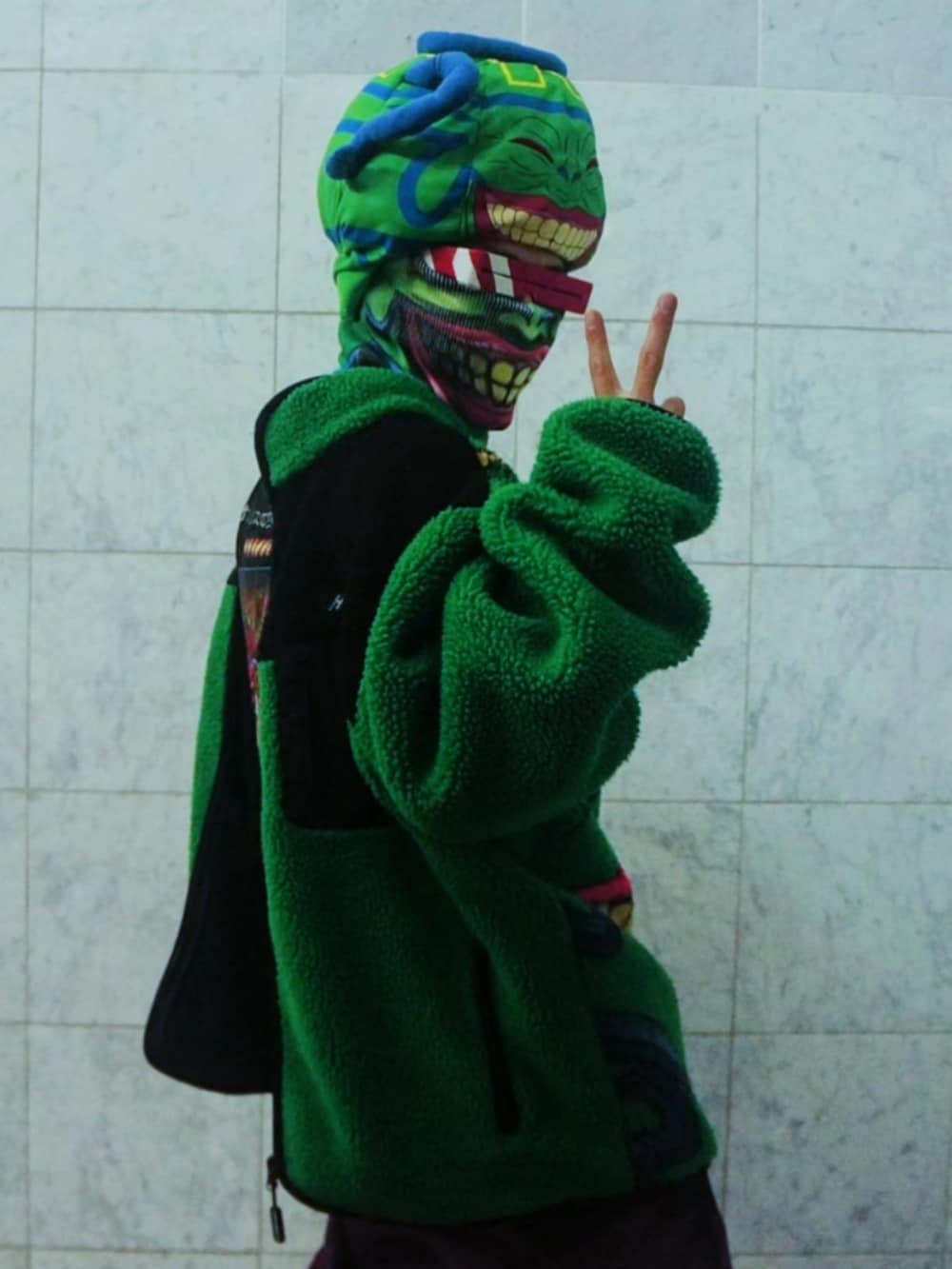 ピンク系のデニムパンツ、ブラック系のブーツ、グリーン系のブルゾンを着用したメンズの秋コーディネートの2枚目の写真