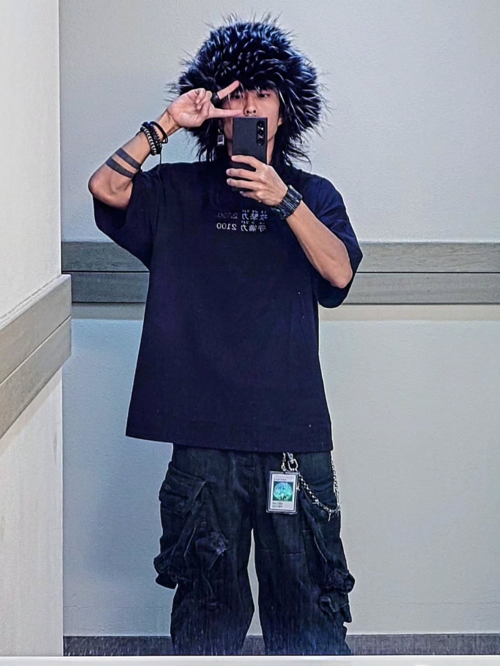 ブラック系のTシャツ/カットソー、グリーン系のカーゴパンツ、ブラック系のキャップを着用したメンズの秋コーディネートの3枚目の写真