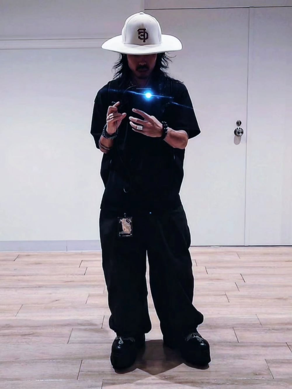 グリーン系のその他パンツ、ブラック系のブーツ、ブラック系のTシャツ/カットソーを着用したメンズの夏コーディネートの2枚目の写真
