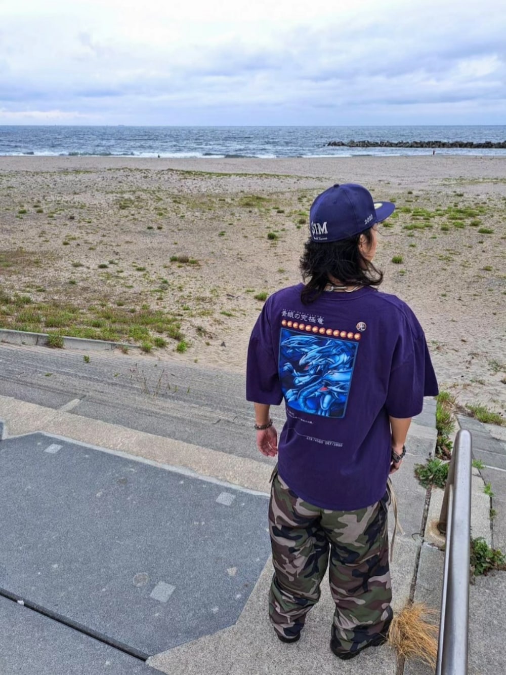 パープル系のTシャツ/カットソー、その他のカーゴパンツ、ブラック系のシューズを着用したメンズの夏コーディネートの2枚目の写真