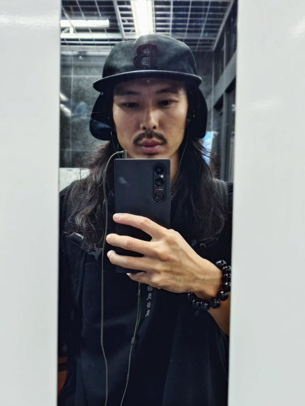 グレー系のデニムパンツ、ブラック系のブーツ、ブラック系のTシャツ/カットソーを着用したメンズの秋コーディネートの2枚目の写真