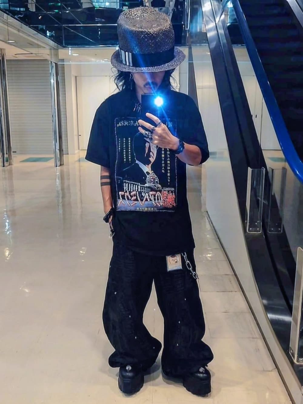 ブラック系のTシャツ/カットソー、ブラック系のハット、シルバー系のピアス（片耳用）を着用したメンズの秋コーディネートの2枚目の写真