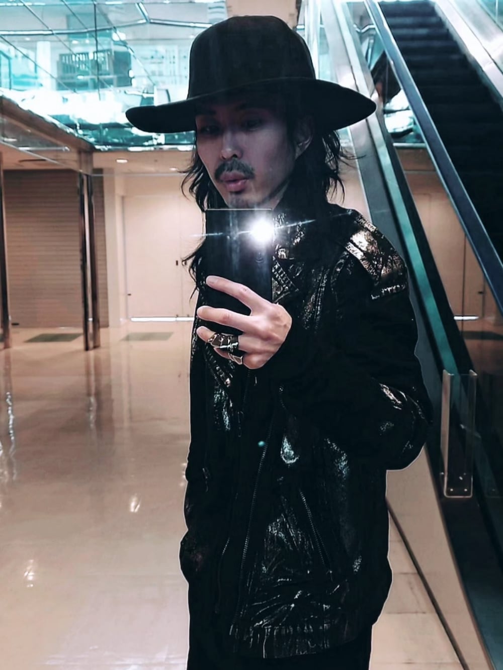 シルバー系のデニムパンツ、シルバー系のライダースジャケット、ブラック系のブーツを着用したメンズの春コーディネートの2枚目の写真