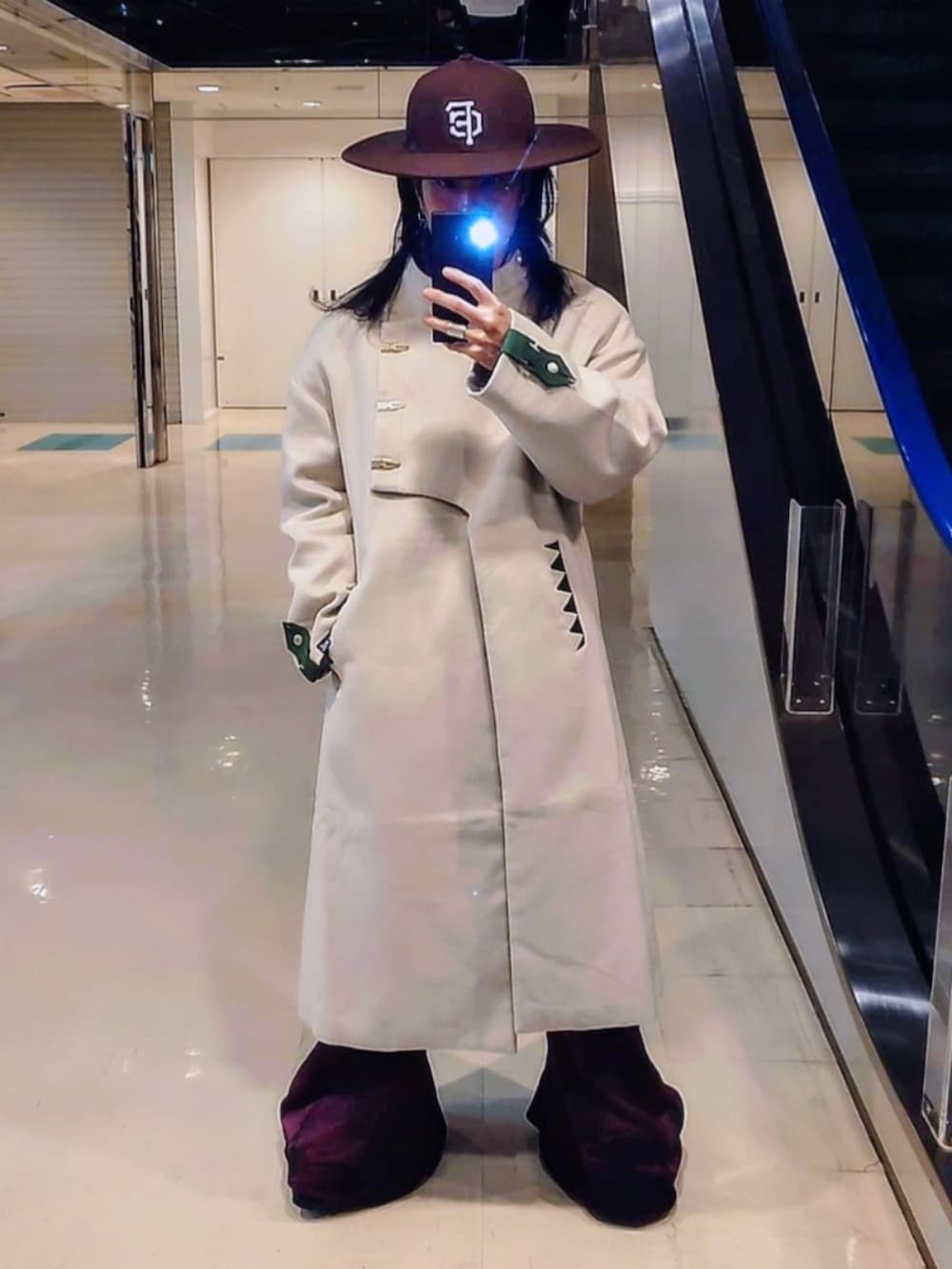 ベージュ系のノーカラーコート、ピンク系のデニムパンツ、ブラック系のブーツを着用したメンズの春コーディネートの5枚目の写真