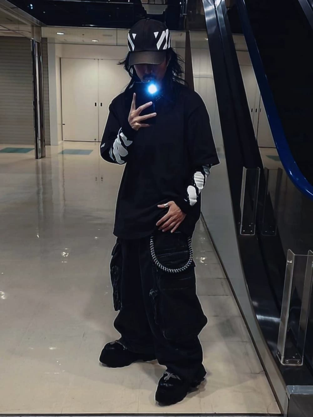 ブルー系のパンツ、ブラック系のブーツ、ブラック系のTシャツ/カットソーを着用したメンズの春コーディネートの4枚目の写真