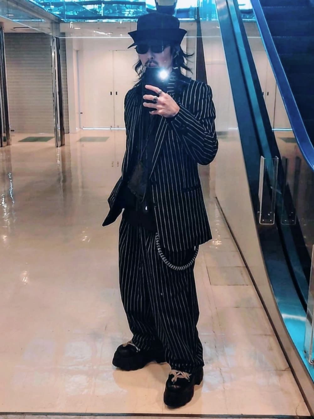 ブラック系のジャケット/アウター、ブラック系のブーツ、ブラック系のスラックスを着用したメンズの春コーディネートの3枚目の写真