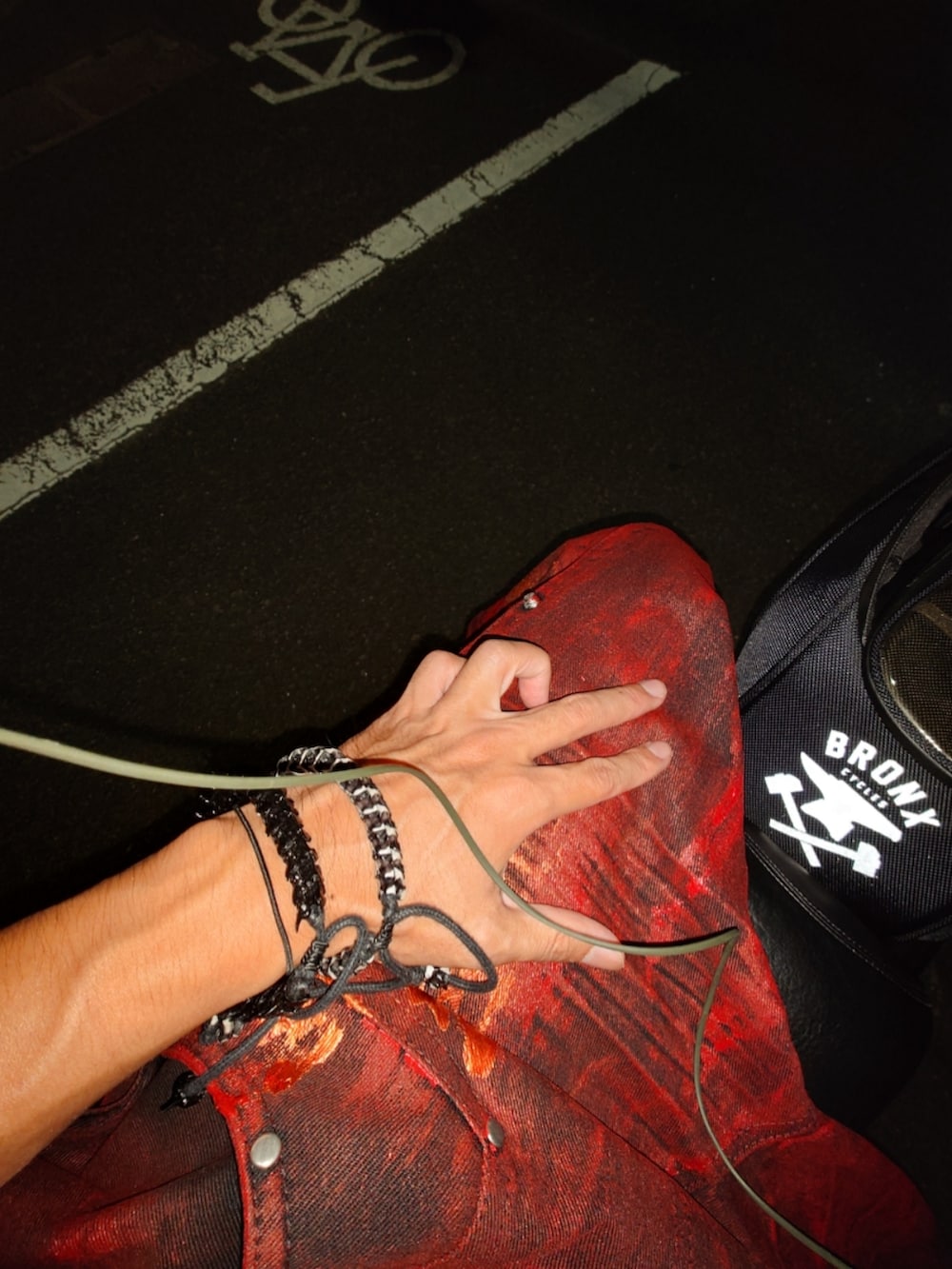 レッド系のデニムパンツ、ブラック系のシューズ、ブラック系のバックパック/リュックを着用したメンズの冬コーディネートの2枚目の写真