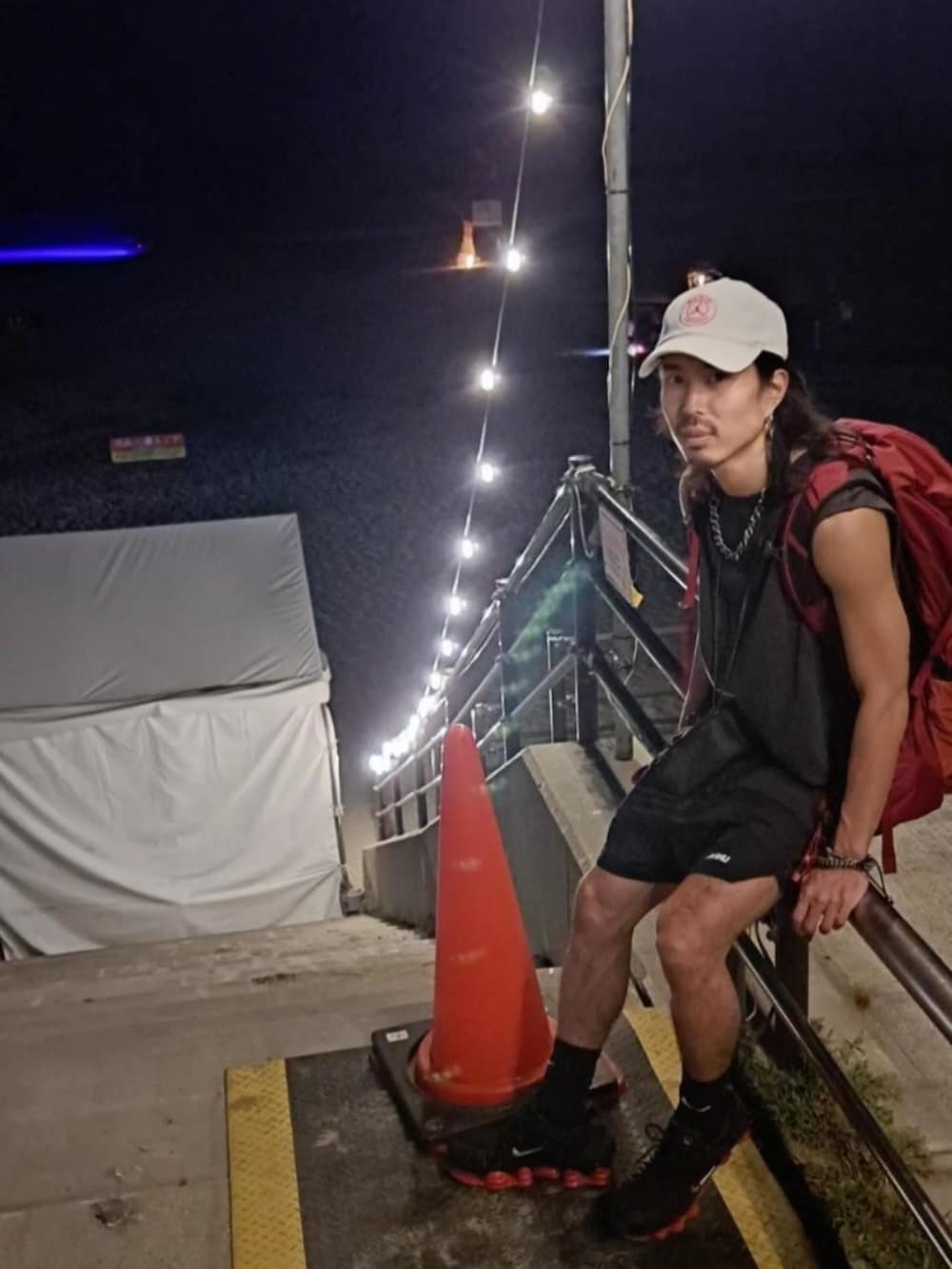 ブラック系のその他パンツ、ブラック系のスニーカー、レッド系のバックパック/リュックを着用したメンズの夏コーディネートの3枚目の写真