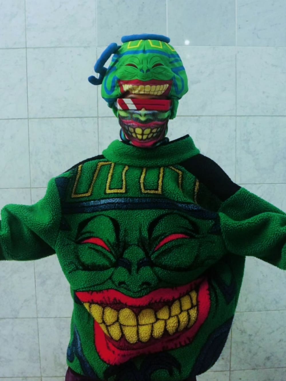 ピンク系のデニムパンツ、ブラック系のブーツ、グリーン系のブルゾンを着用したメンズの秋コーディネートの3枚目の写真