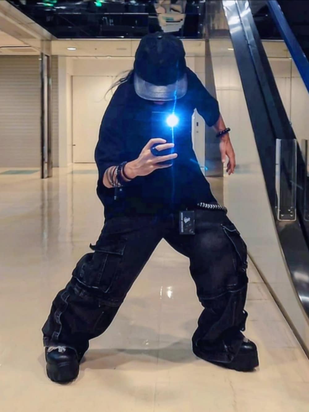 グレー系のデニムパンツ、ブラック系のTシャツ/カットソー、ブラック系のブーツを着用したメンズの秋コーディネートの3枚目の写真
