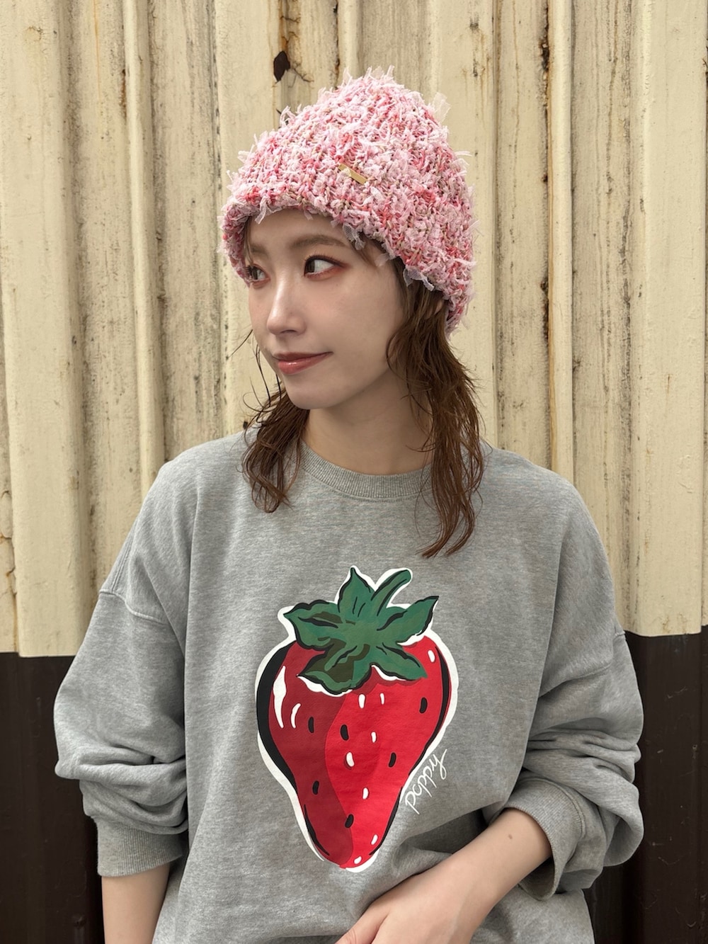 グレー系のスウェット、レッド系のスカート、グレー系のスニーカーを着用したレディースの秋コーディネートの2枚目の写真
