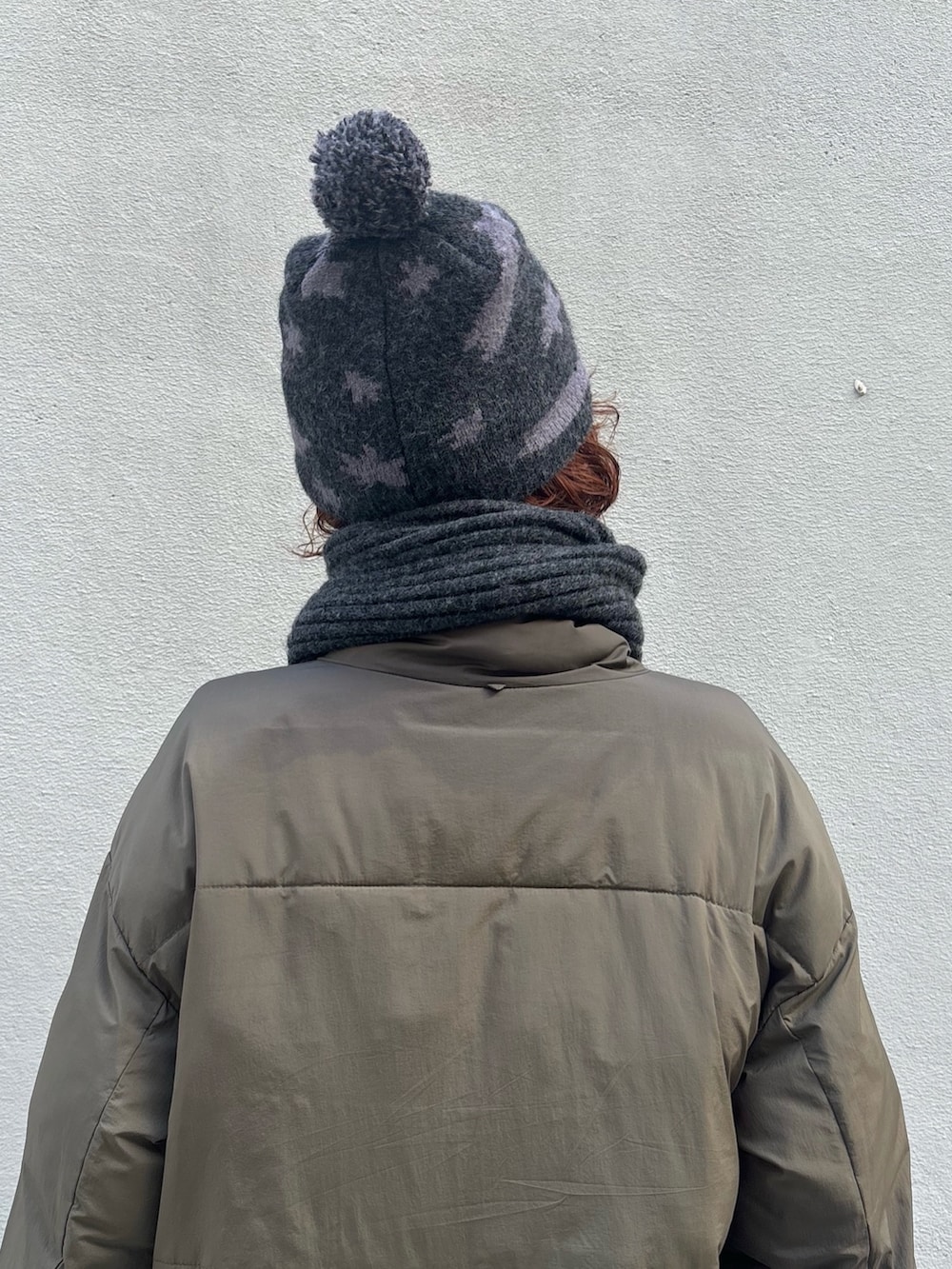 グリーン系のダウンジャケット/コート、グレー系のパンツ、ブラウン系のモカシン/デッキシューズを着用したレディースの冬コーディネートの4枚目の写真