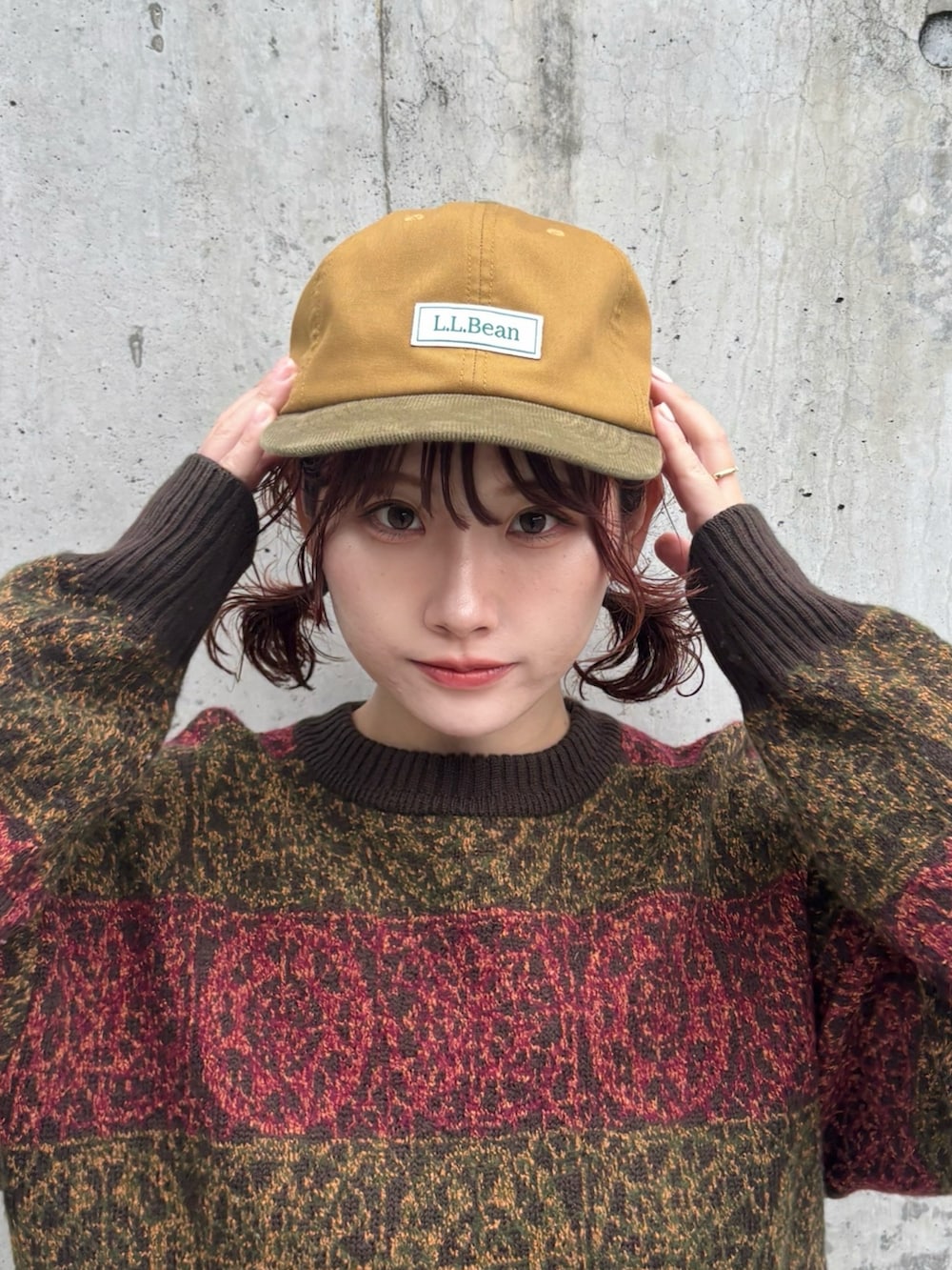 ブルー系のデニムスカート、ブラウン系のモカシン/デッキシューズ、ブラウン系のニット/セーターを着用したレディースの秋コーディネートの2枚目の写真