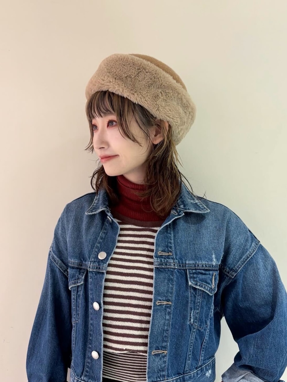 ブラウン系のタンクトップ、ブルー系のデニムジャケット、レッド系のトップスを着用したレディースの冬コーディネートの2枚目の写真