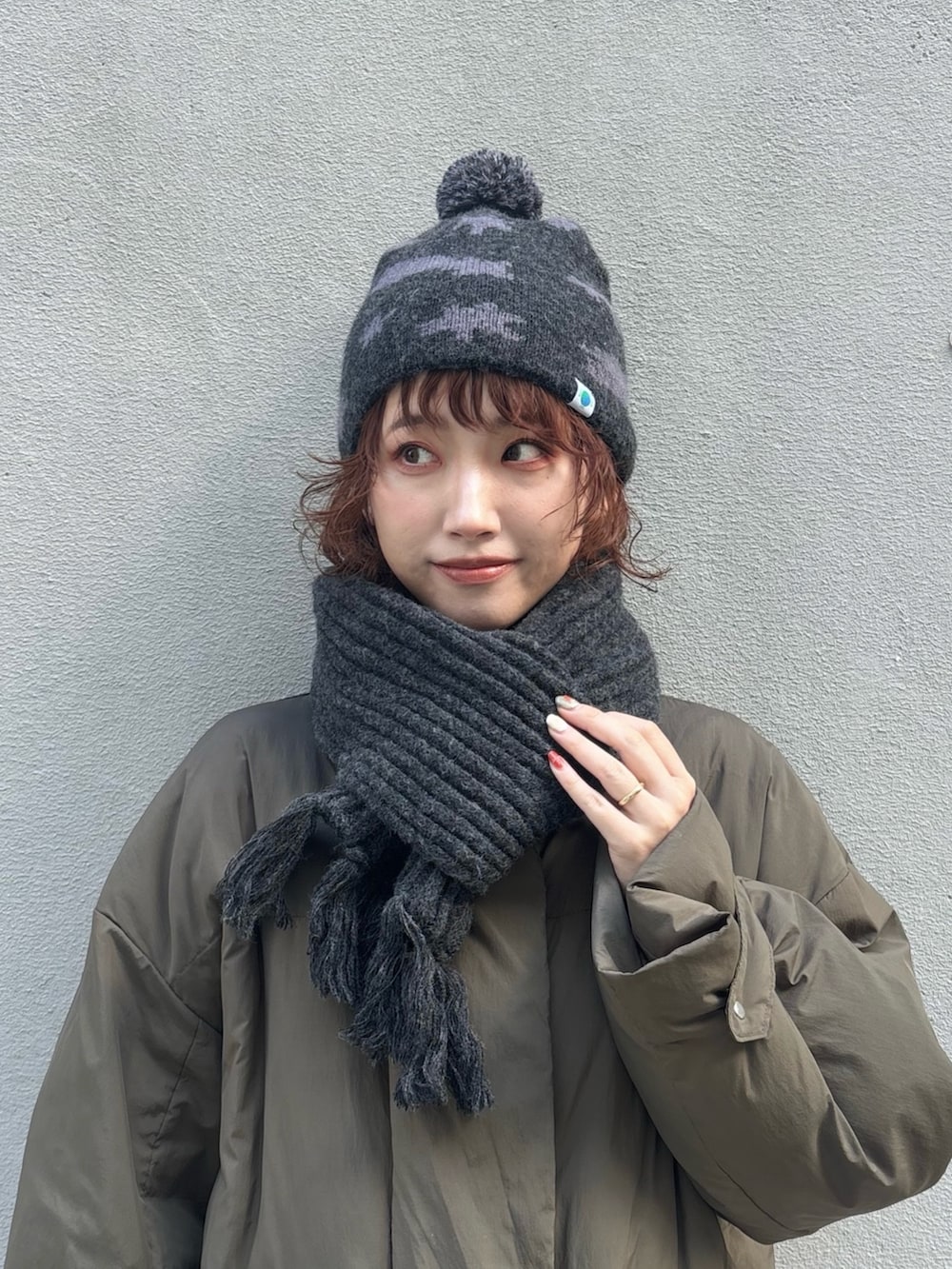 グリーン系のダウンジャケット/コート、グレー系のパンツ、ブラウン系のモカシン/デッキシューズを着用したレディースの冬コーディネートの3枚目の写真