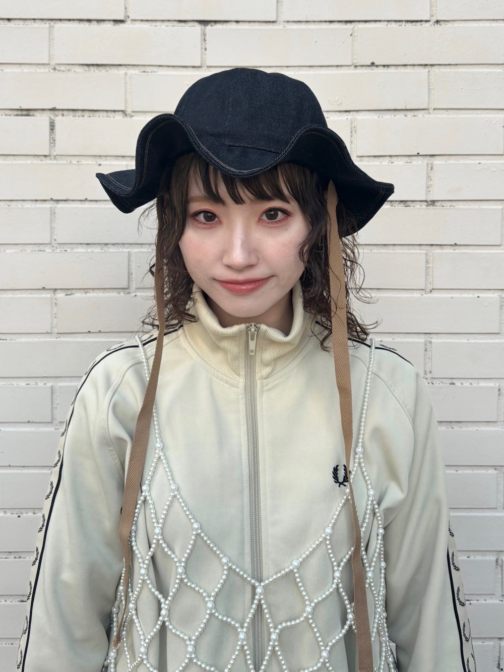 ピンク系のワンピース、ブラック系のスカート、グレー系のスニーカーを着用したレディースの冬コーディネートの2枚目の写真