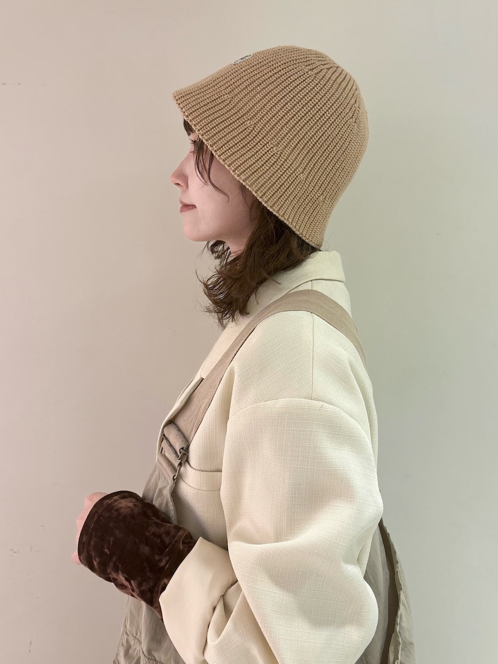 ブラウン系のTシャツ/カットソー、ベージュ系のベスト、ホワイト系のテーラードジャケットを着用したレディースの春コーディネートの2枚目の写真