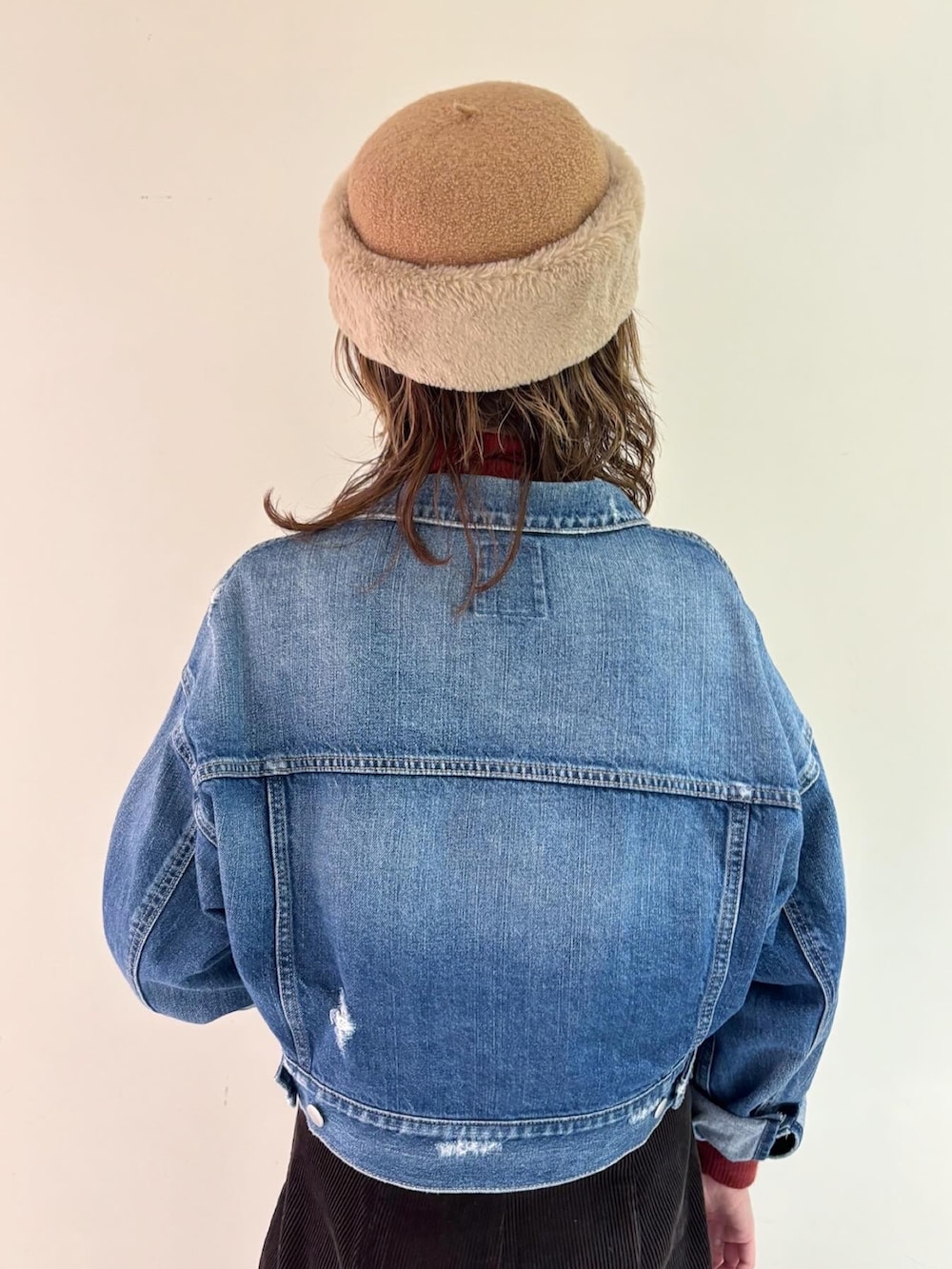 ブラウン系のタンクトップ、ブルー系のデニムジャケット、レッド系のトップスを着用したレディースの冬コーディネートの4枚目の写真