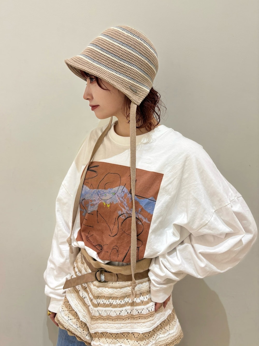 ホワイト系のTシャツ/カットソー、ベージュ系のパンツ、ブルー系のデニムパンツを着用したレディースの冬コーディネートの2枚目の写真
