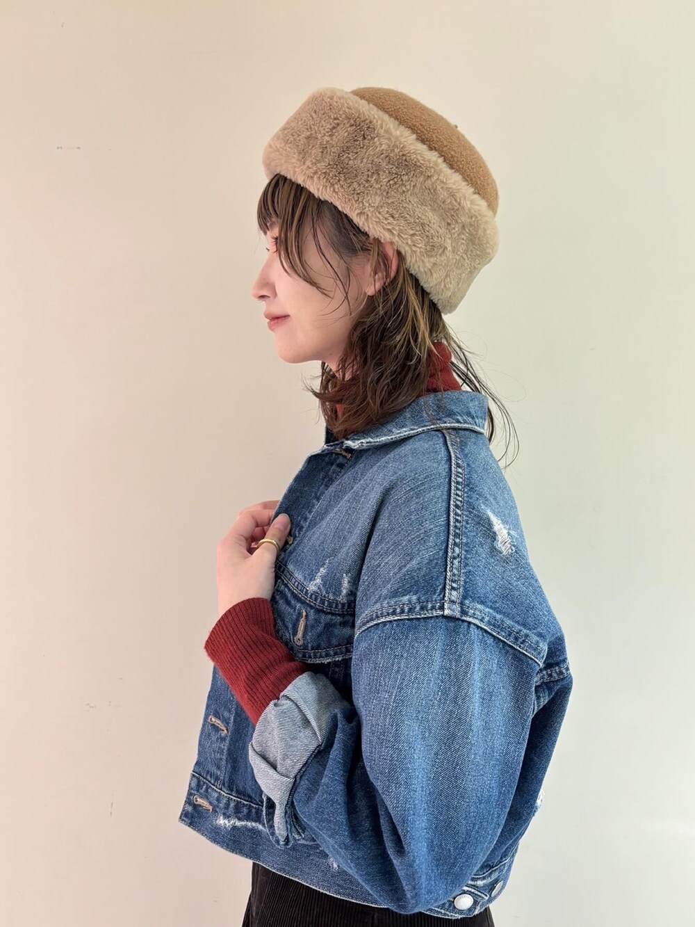 ブラウン系のタンクトップ、ブルー系のデニムジャケット、レッド系のトップスを着用したレディースの冬コーディネートの3枚目の写真