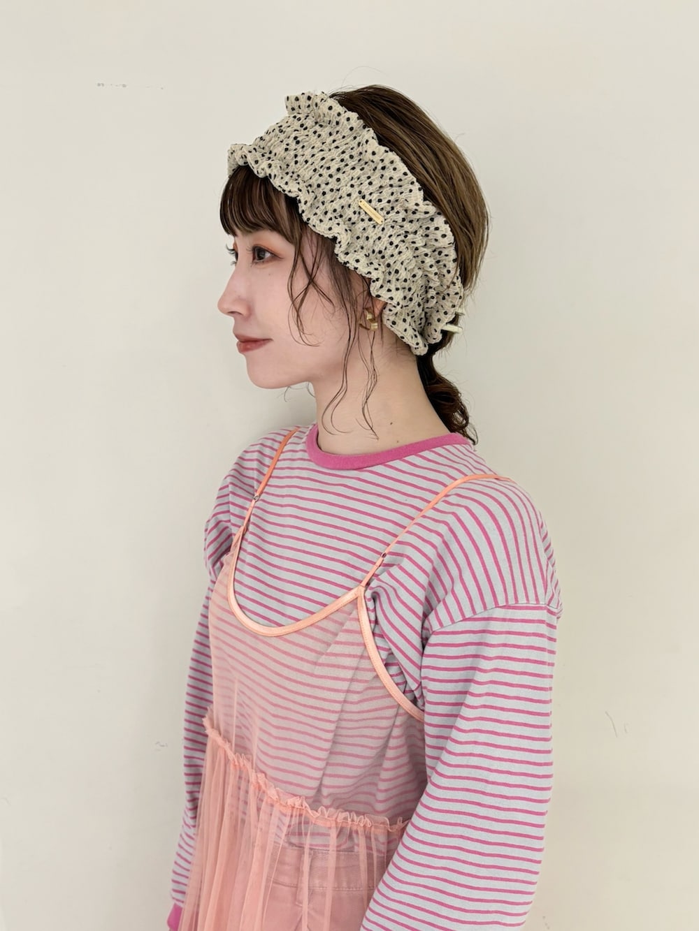 ピンク系のTシャツ/カットソー、ピンク系のワンピース、ベージュ系のスニーカーを着用したレディースの春コーディネートの2枚目の写真
