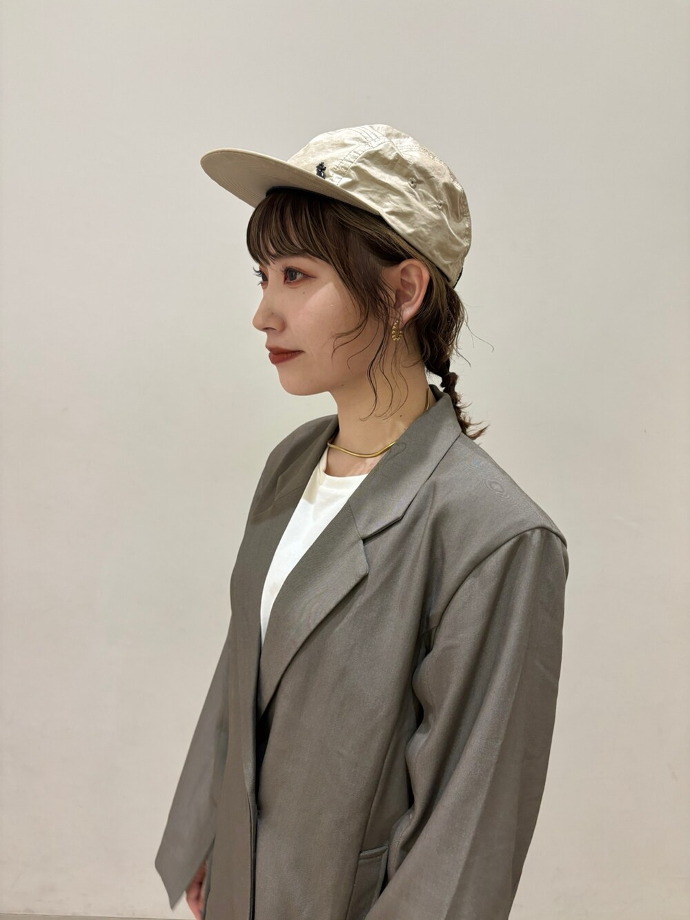 ブラウン系のテーラードジャケット、ブラウン系のスラックス、ベージュ系のスニーカーを着用したレディースの春コーディネートの2枚目の写真