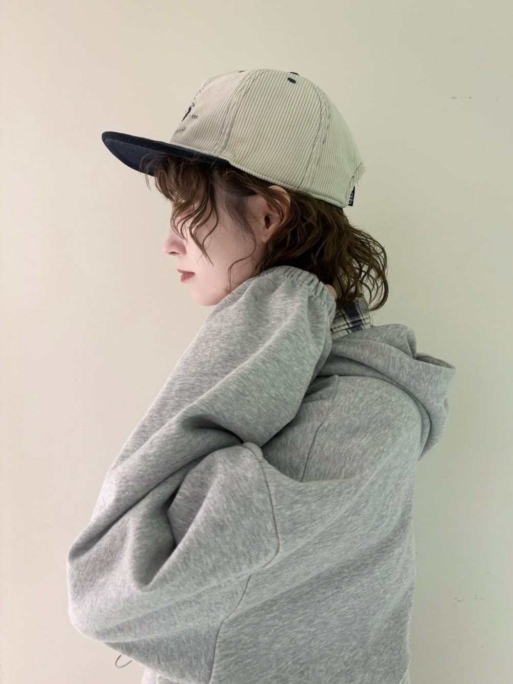 グレー系のパーカー、ブルー系のシャツ/ブラウス、ブラック系のデニムパンツを着用したレディースの秋コーディネートの3枚目の写真