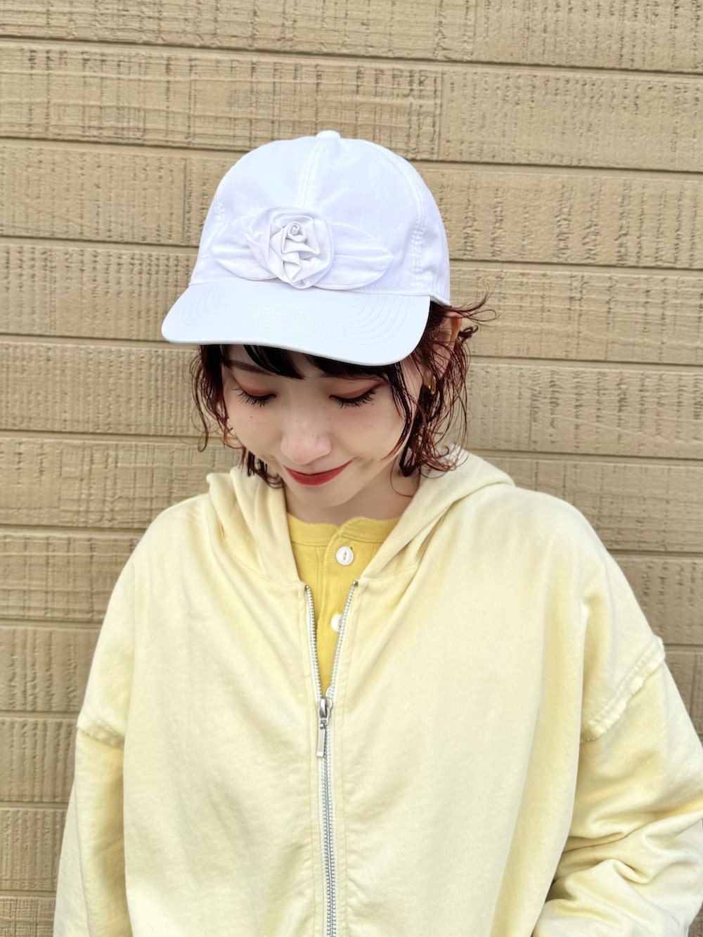 イエロー系のパーカー、ホワイト系のスカート、ホワイト系のその他パンツを着用したレディースの冬コーディネートの2枚目の写真