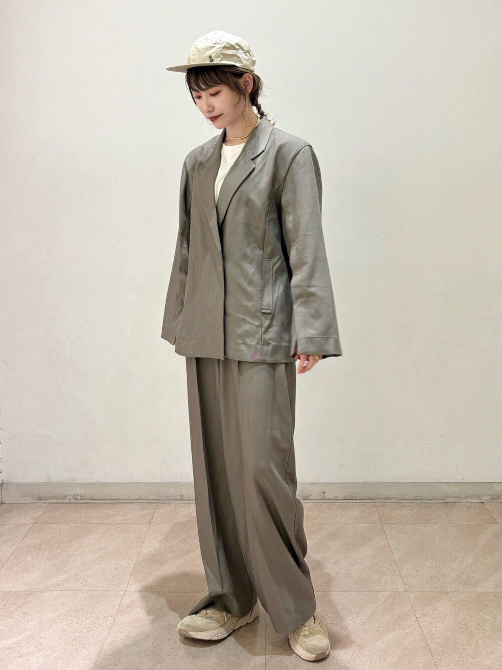 ブラウン系のテーラードジャケット、ブラウン系のスラックス、ベージュ系のスニーカーを着用したレディースの春コーディネートの4枚目の写真