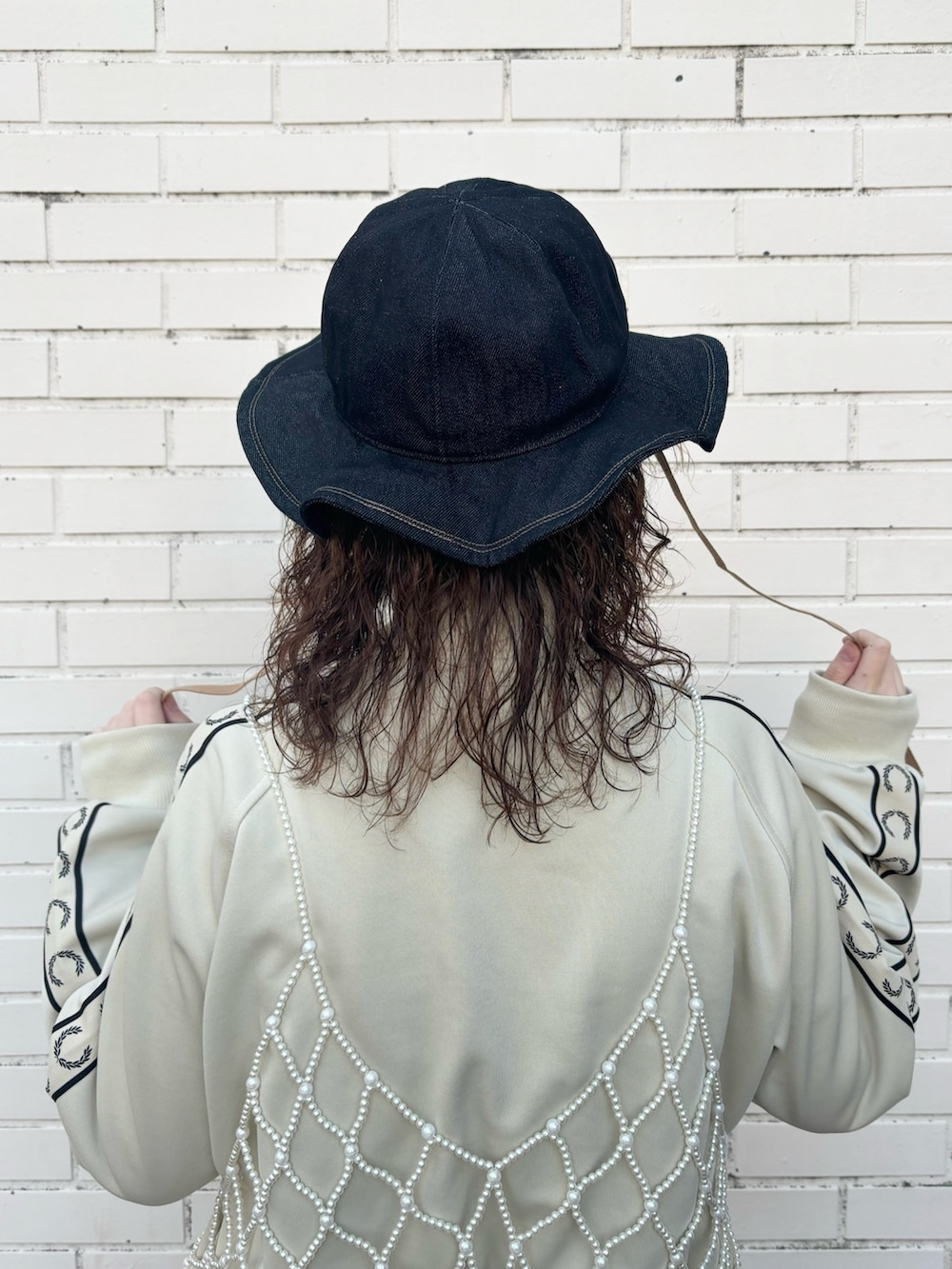 ピンク系のワンピース、ブラック系のスカート、グレー系のスニーカーを着用したレディースの冬コーディネートの3枚目の写真