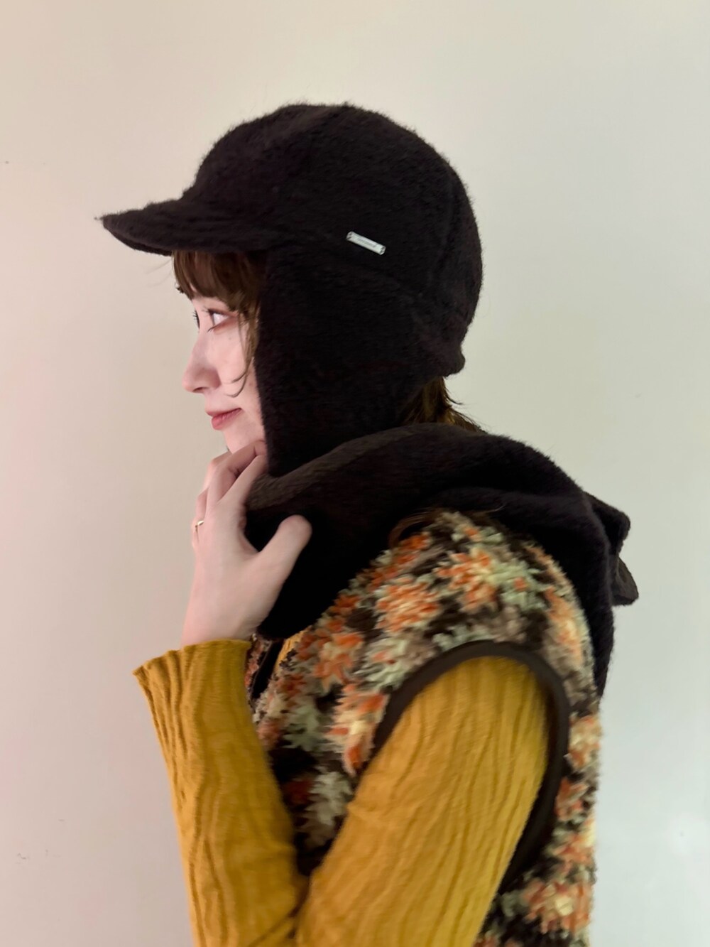 ベージュ系のベスト、ブラウン系のパンツ、イエロー系のスニーカーを着用したレディースの秋コーディネートの3枚目の写真