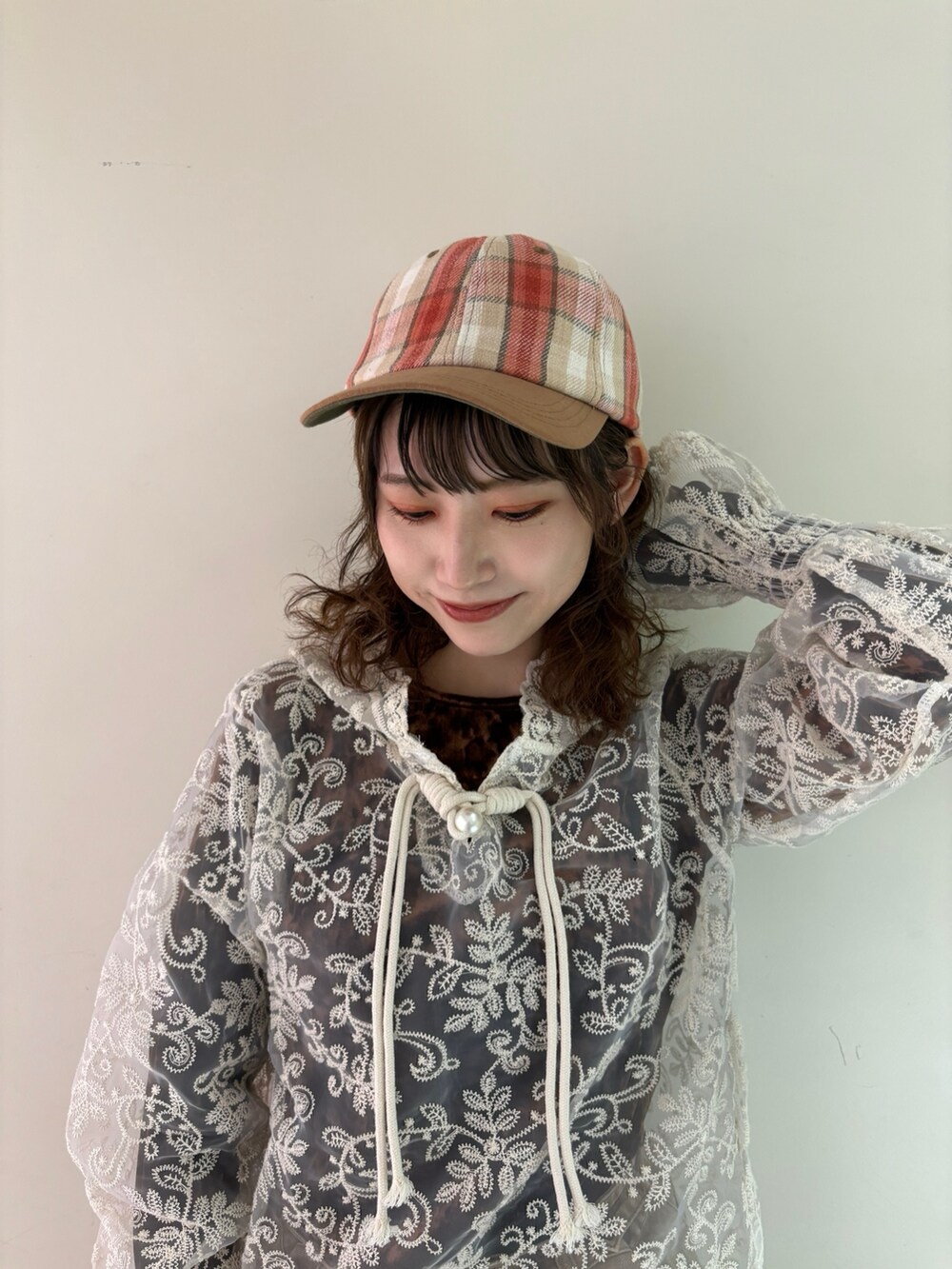 ブラウン系のTシャツ/カットソー、ブラウン系のデニムパンツ、ベージュ系のスニーカーを着用したレディースの春コーディネートの2枚目の写真