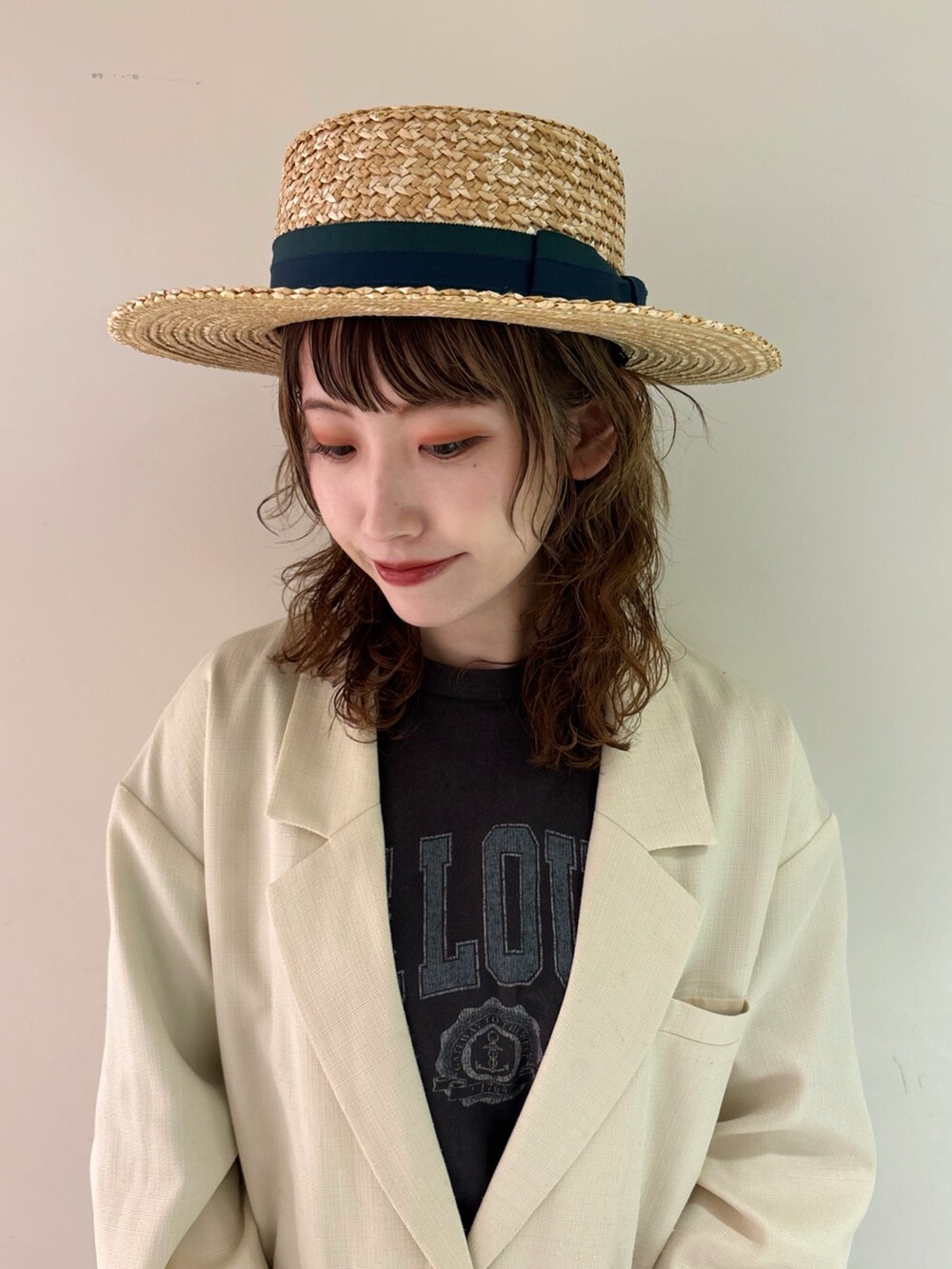 ホワイト系のテーラードジャケット、グレー系のTシャツ/カットソー、グリーン系のデニムパンツを着用したレディースの春コーディネートの2枚目の写真