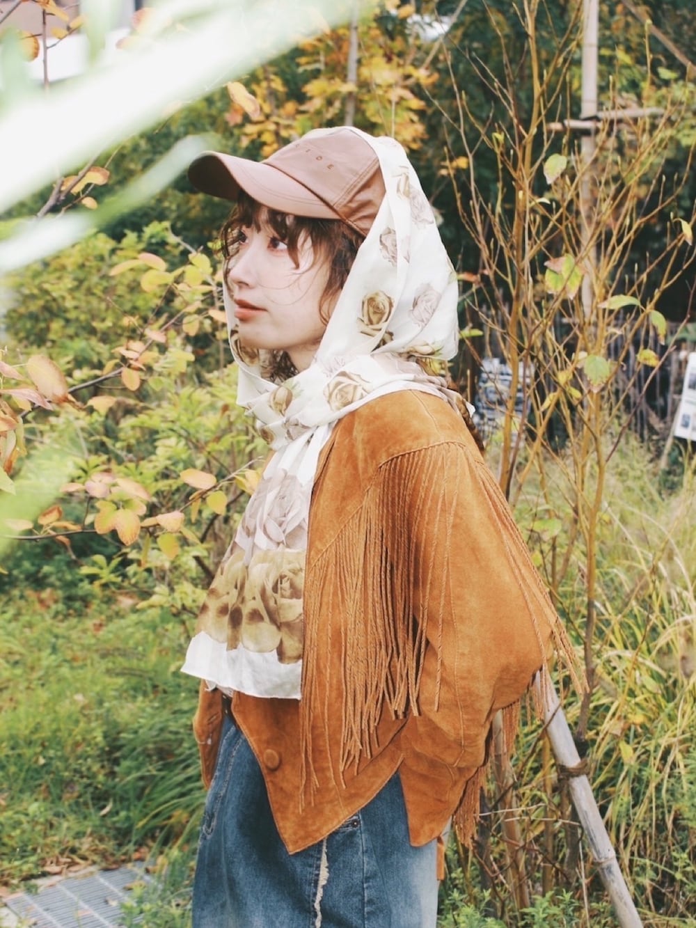 ブラウン系のTシャツ/カットソー、ベージュ系のベスト、ブラウン系のモカシン/デッキシューズを着用したレディースの秋コーディネートの3枚目の写真