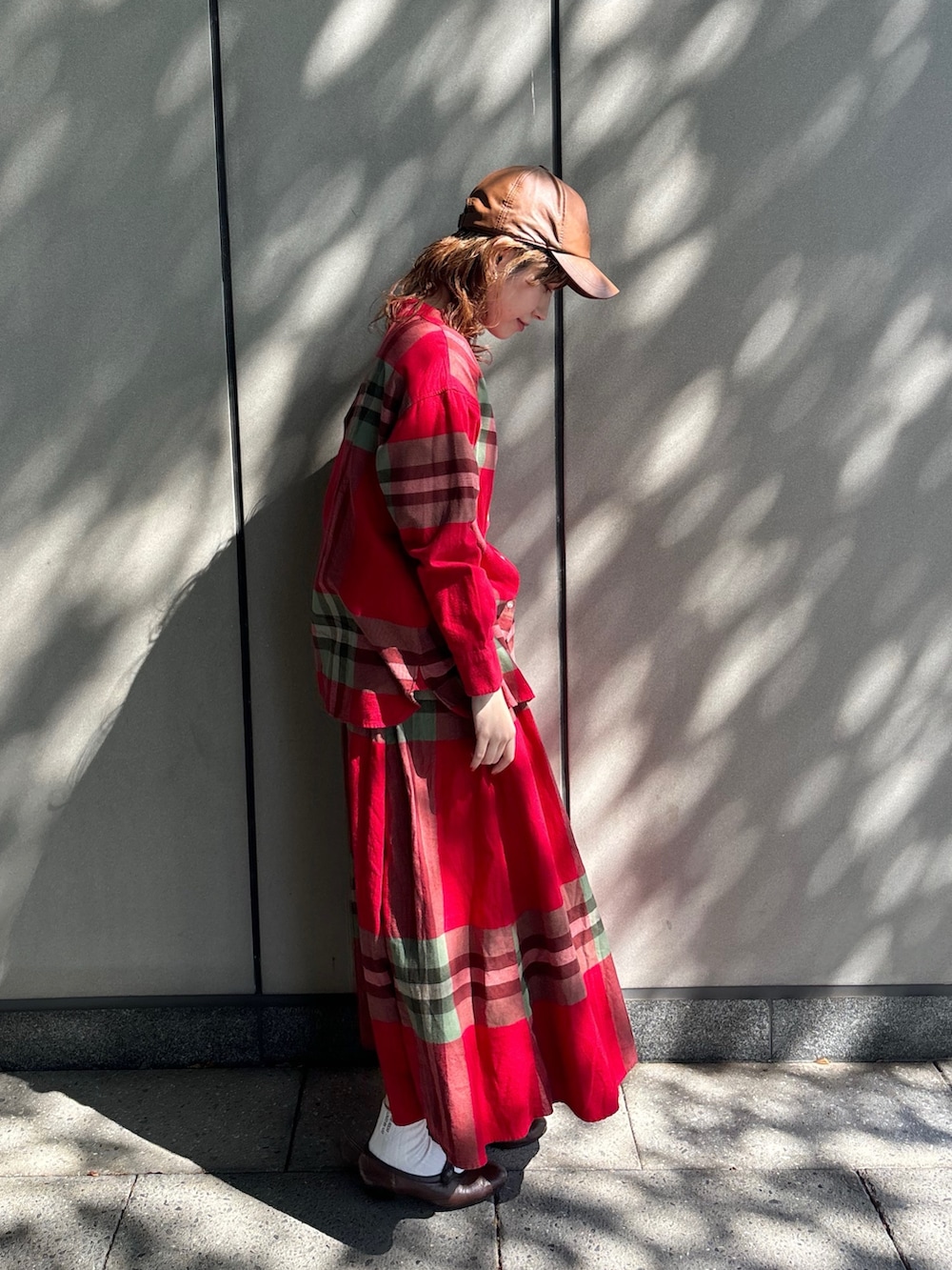 レッド系のシャツ/ブラウス、レッド系のスカート、ブラウン系のパンプスを着用したレディースの秋コーディネートの3枚目の写真