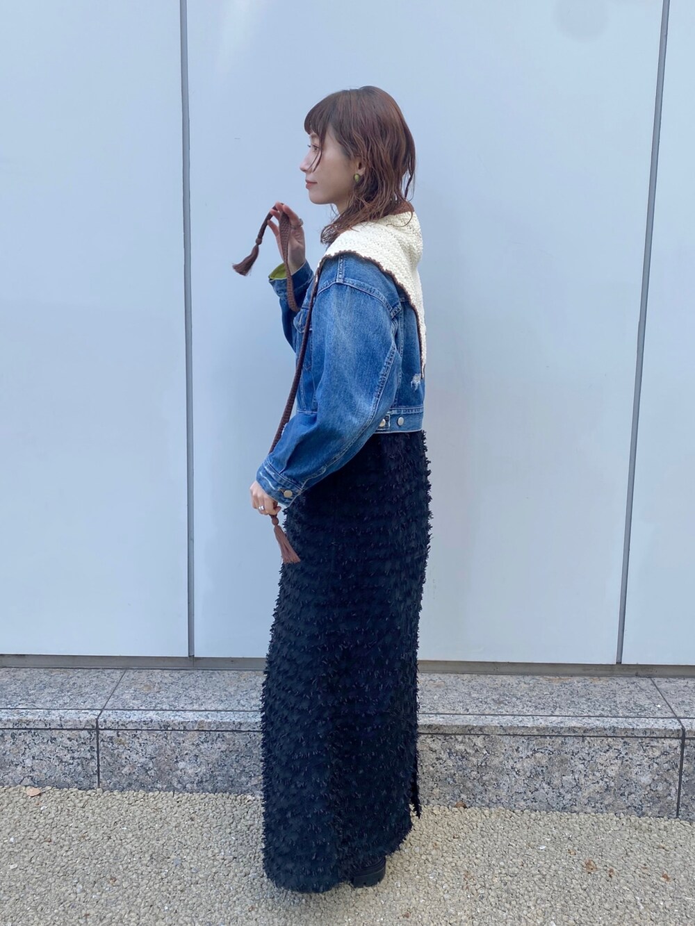 ブルー系のデニムジャケット、ブラック系のワンピース、ホワイト系のバンダナ/スカーフを着用したレディースの春コーディネートの2枚目の写真