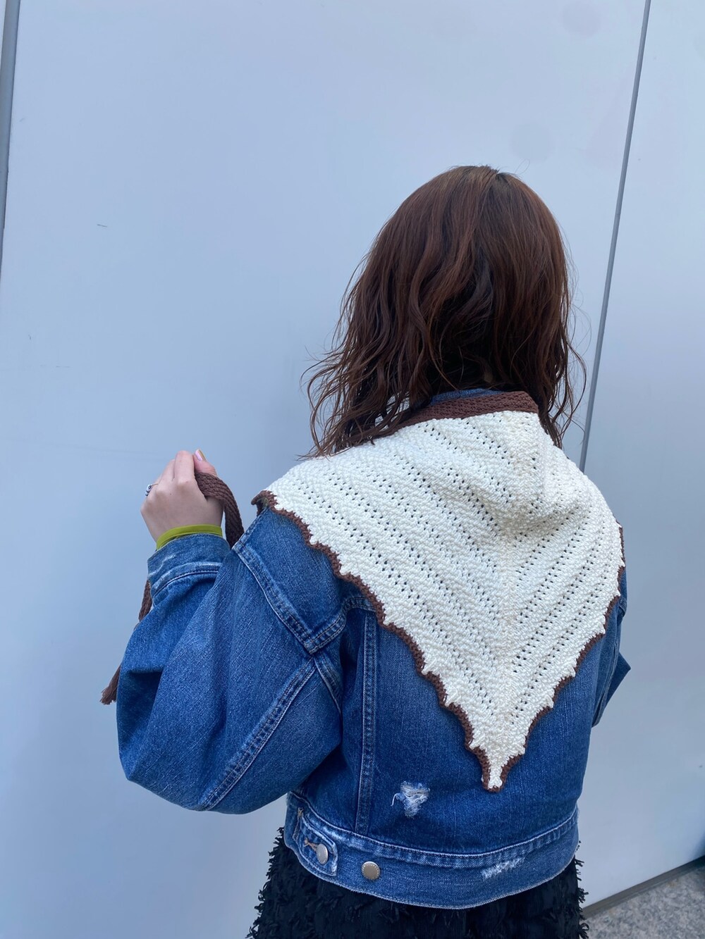 ブルー系のデニムジャケット、ブラック系のワンピース、ホワイト系のバンダナ/スカーフを着用したレディースの春コーディネートの3枚目の写真