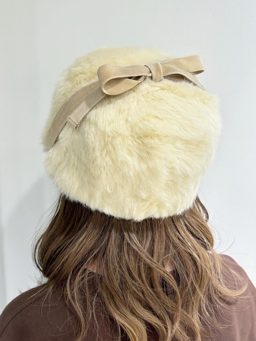 ベージュ系のベスト、イエロー系のTシャツ/カットソー、ブラウン系のデニムスカートを着用したレディースの秋コーディネートの5枚目の写真