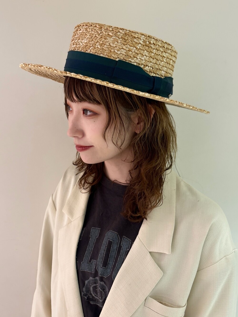 ホワイト系のテーラードジャケット、グレー系のTシャツ/カットソー、グリーン系のデニムパンツを着用したレディースの春コーディネートの5枚目の写真