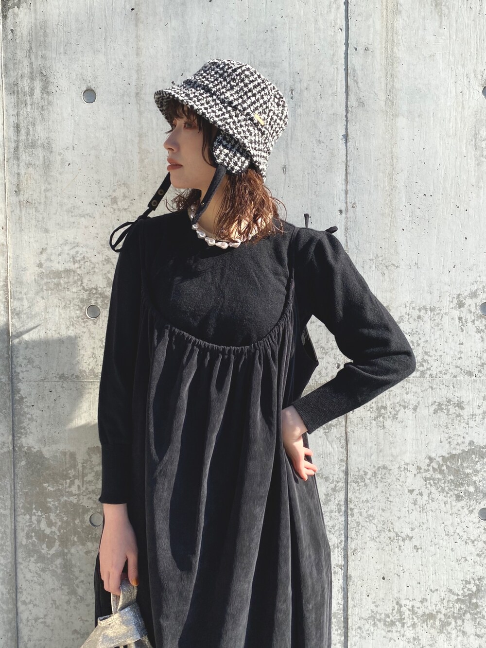 ブラック系のニット/セーター、ブラック系のワンピース、ブラック系のブーツを着用したレディースの秋コーディネートの2枚目の写真