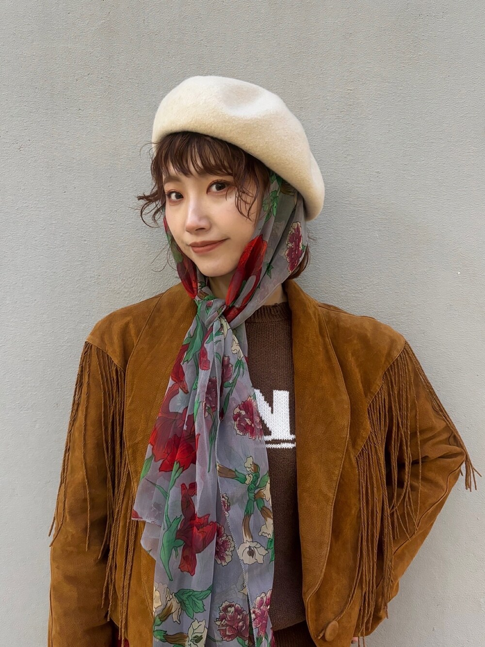 ブラウン系のジャケット/アウター、ブラウン系のニット/セーター、レッド系のスカートを着用したレディースの冬コーディネートの2枚目の写真