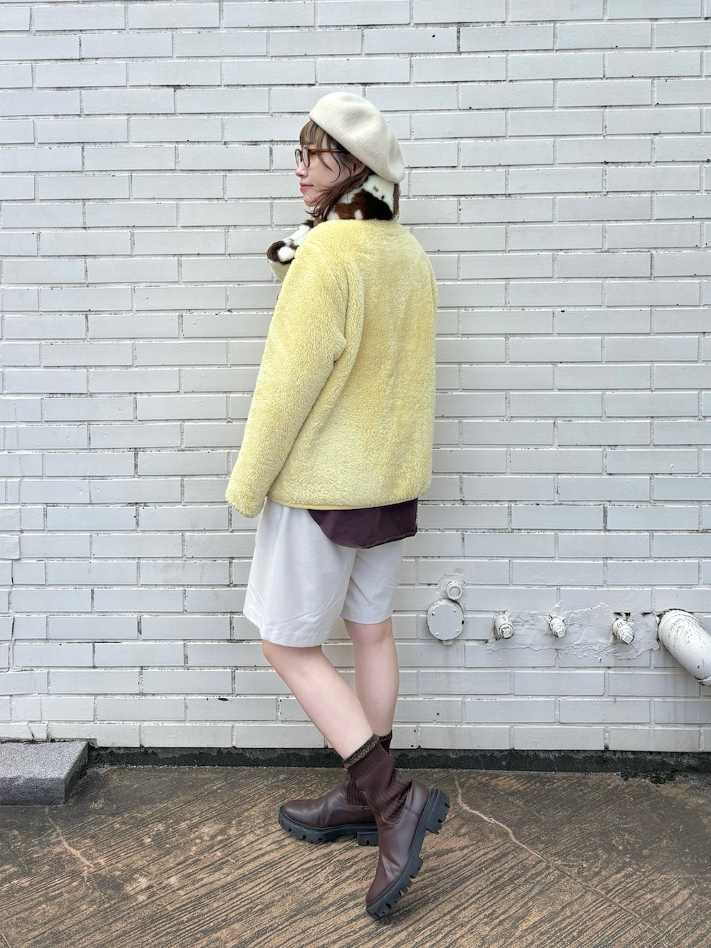 イエロー系のジャケット/アウター、ホワイト系のパンツ、ブラウン系のブーツを着用したレディースの冬コーディネートの2枚目の写真