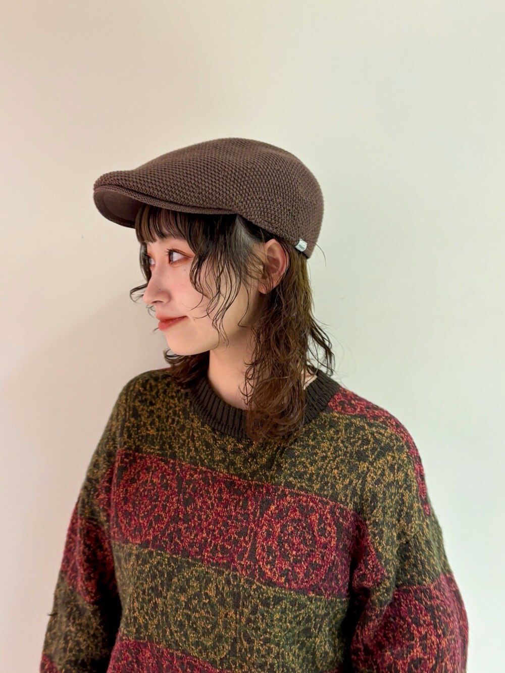 ブラウン系のニット/セーター、ブラウン系のデニムスカート、ブラウン系のブーツを着用したレディースの冬コーディネートの2枚目の写真