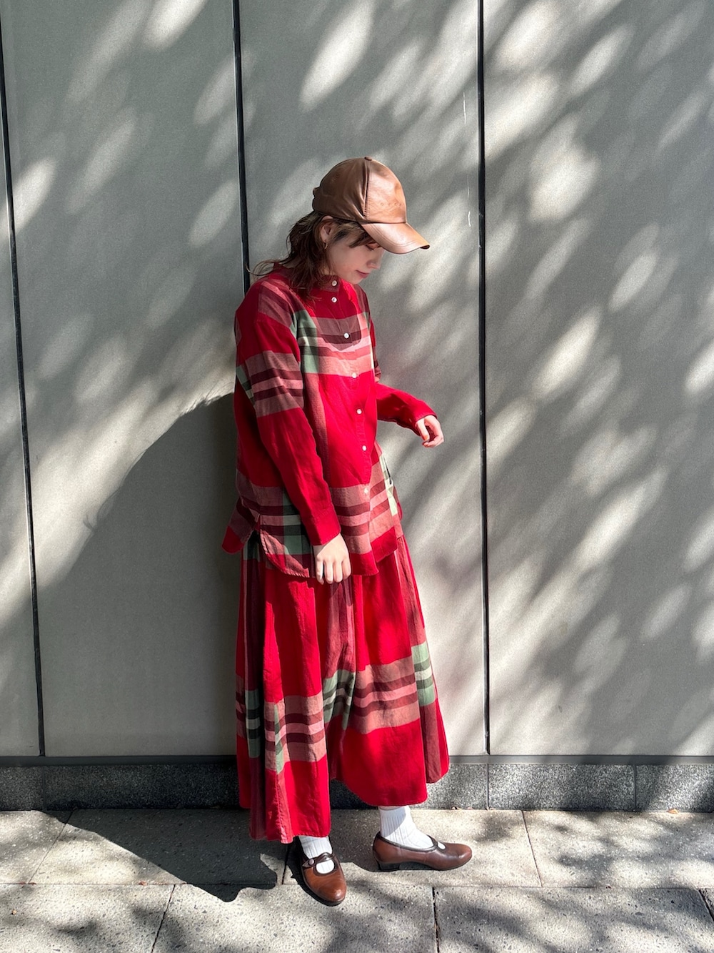 レッド系のシャツ/ブラウス、レッド系のスカート、ブラウン系のパンプスを着用したレディースの秋コーディネートの2枚目の写真