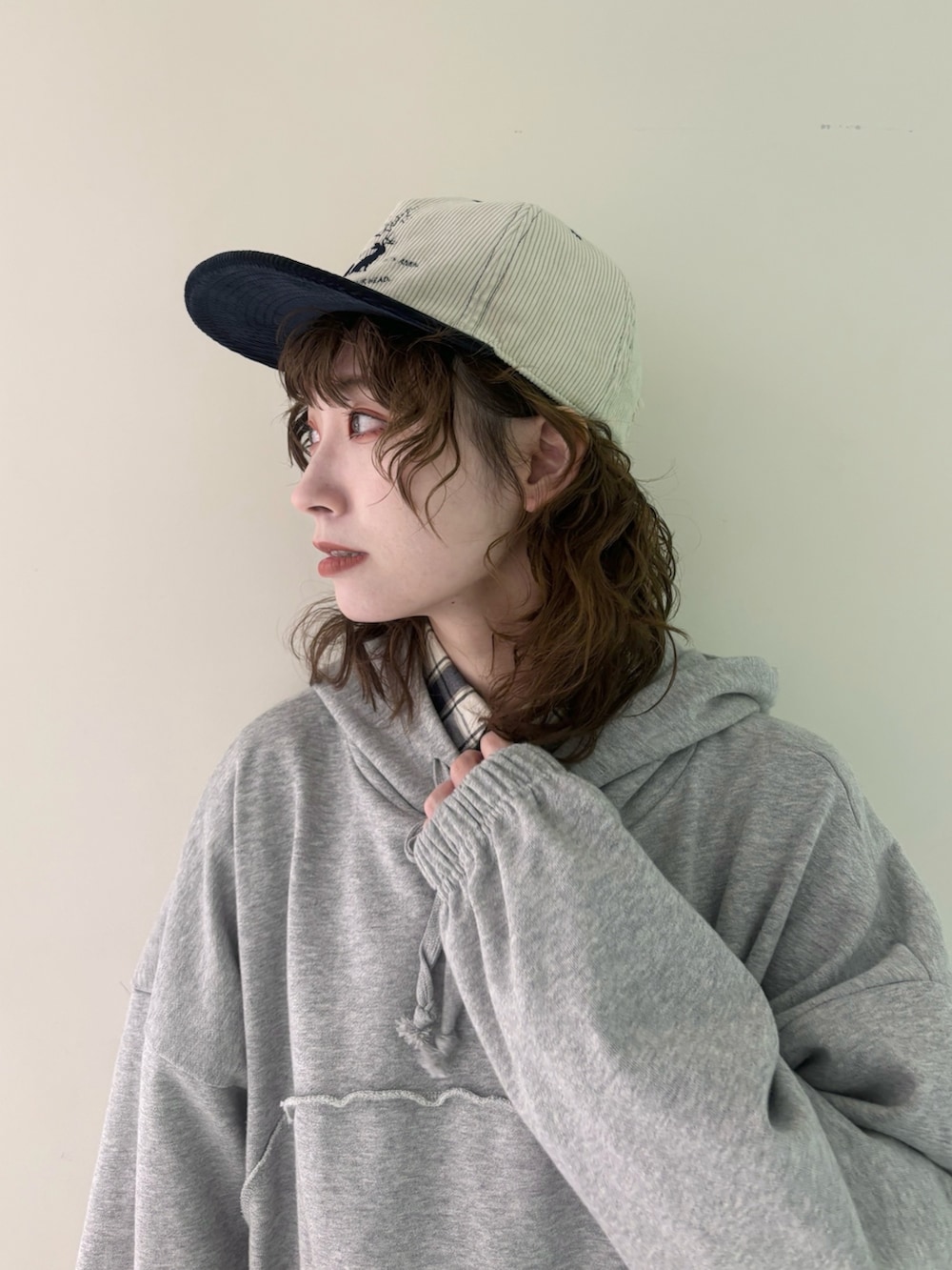 グレー系のパーカー、ブルー系のシャツ/ブラウス、ブラック系のデニムパンツを着用したレディースの秋コーディネートの2枚目の写真