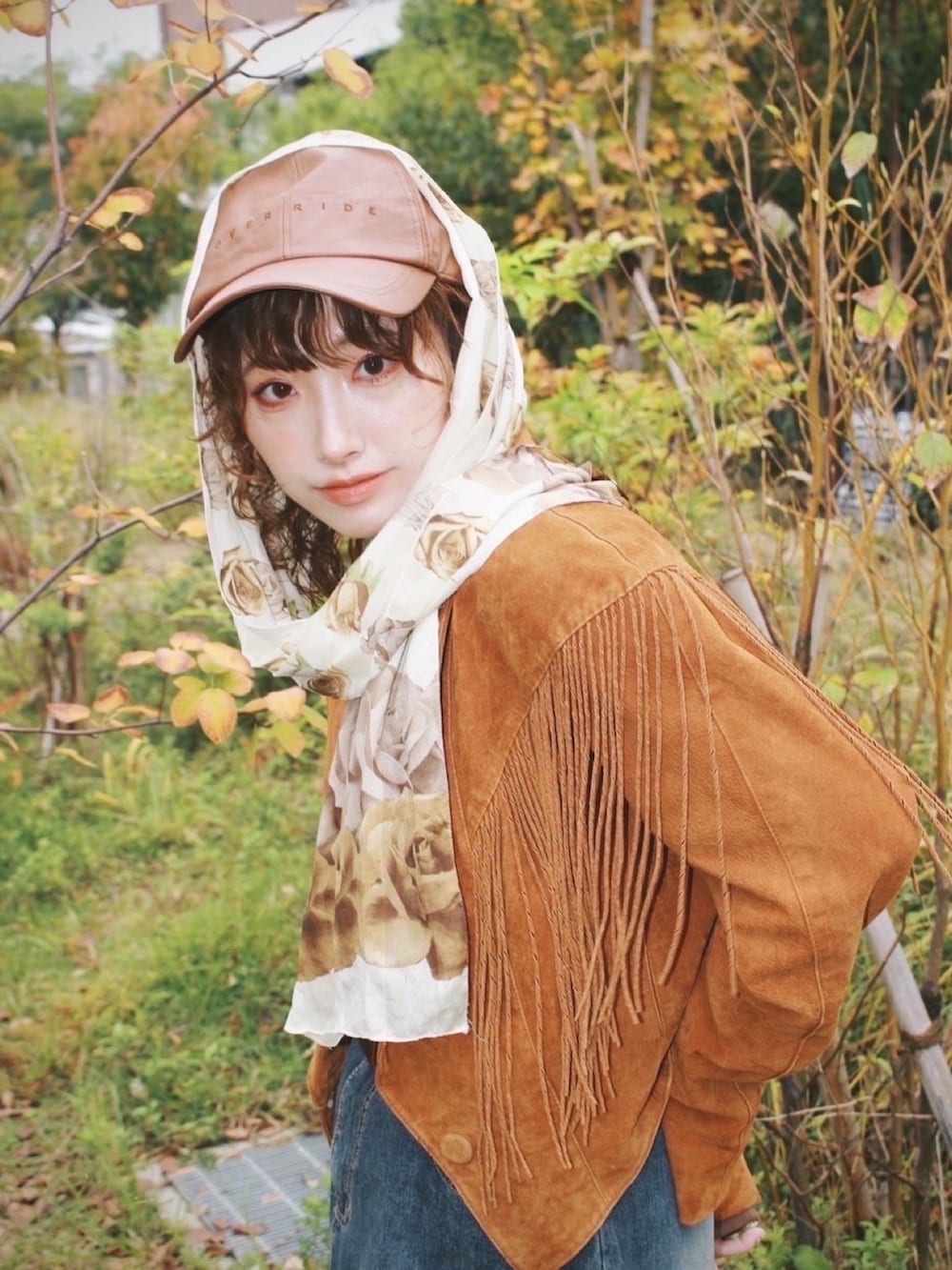 ブラウン系のTシャツ/カットソー、ベージュ系のベスト、ブラウン系のモカシン/デッキシューズを着用したレディースの秋コーディネートの2枚目の写真