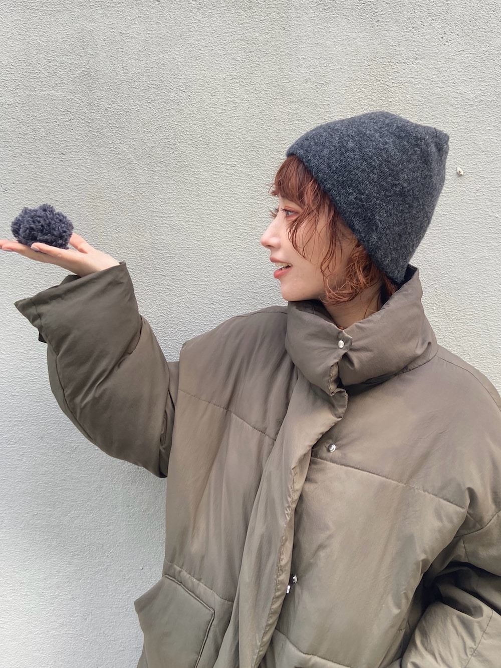 グリーン系のダウンジャケット/コート、グレー系のパンツ、ブラウン系のモカシン/デッキシューズを着用したレディースの冬コーディネートの7枚目の写真