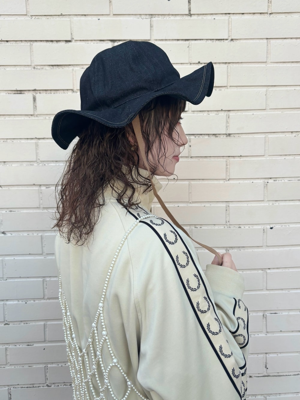 ピンク系のワンピース、ブラック系のスカート、グレー系のスニーカーを着用したレディースの冬コーディネートの4枚目の写真